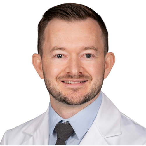 Smiling male doctor in a white coat and light blue shirt, facing the camera.